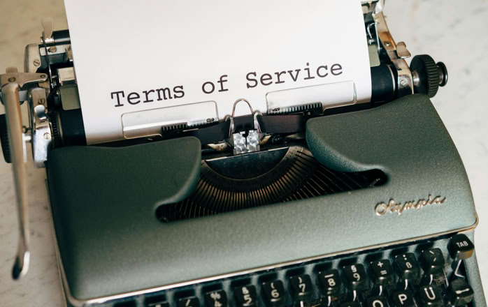 Close-up of a vintage typewriter printing 'Terms of Service' on paper, ideal for legal and business themes.